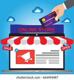 Online shopping concept with silver open shop laptop with and on the screen the text sale and open - Hand holding credit card for buy online with web site - Online shop store concept