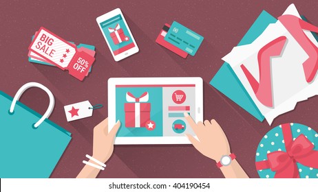 Online shopping and delivery concept, woman buying fashion products from an e-shop using a digital touch screen tablet, flat lay