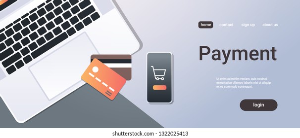 online einkaufen mobile anwendung internet payment konzept top angle view desktop smartphone laptop bildschirm kreditkarte büro zeug horizontal kopierraum