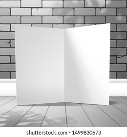 An open blank card stands against a brick wall with the shadow of a Monstera plant. Mockup for design