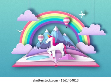 Open fairy tale book with unicorn, rainbow and mountain landscape. Cut out paper art style design