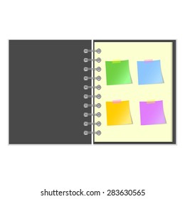 Open grey cover notebook with four colorful stickers on white background