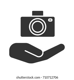 Open hand with camera glyph icon. Photo services. Silhouette symbol. Taking pictures. Negative space. Vector isolated illustration