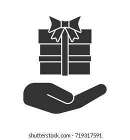 Open hand with gift box glyph icon. Present. Silhouette symbol. Giving, getting gift. Negative space. Vector isolated illustration
