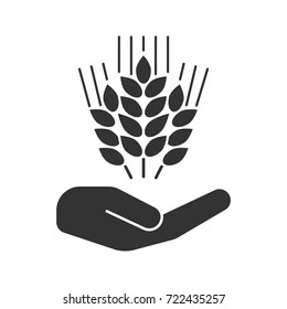 Open hand with wheat ears glyph icon. Silhouette symbol. Growing wheat. Negative space. Vector isolated illustration