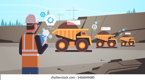 open pit man worker in helmet using mobile app. controlling dumper trucks. professional equipment, working on coal mine production. opencast stone quarry background portrait horizontal.