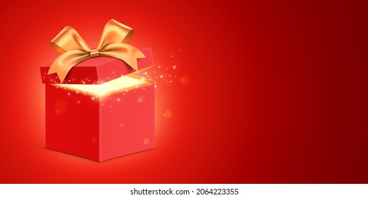 Open red gift box with a golden ribbon and magical glitter light, shining from inside. Shiny present box standing on red gradient background, with copy space. Holiday gift vector banner design.