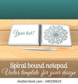 Open square spiral bound notepad on the wooden table with pen. Can be used for business design. Layered illustration. You can paste you picture in to the page.