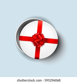 Open white round gift box with shiny red beautiful curly bow and ribbon. Top view, close up. Isolated on blue Background