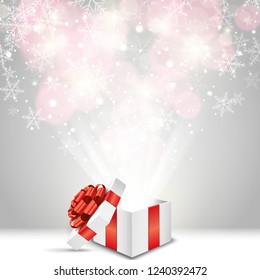 Coffret cadeau ouvert avec arc rouge et flocons de neige