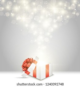 Opened gift box with red bow and lights