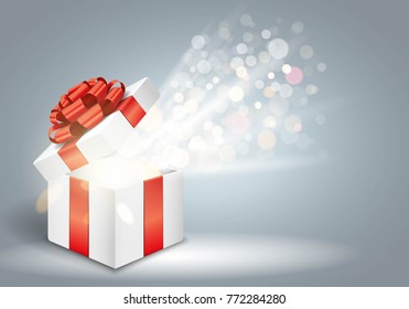 Opened gift box with red bow and glitter lights