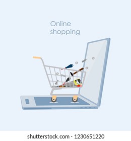  Opened laptop with a trolley filled with tools . Online shopping or e-commerce  concept.