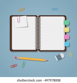 Opened notebook with colored tabs clips and pencil.