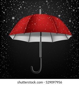 The opened red and white umbrella on falling snow background