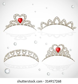 Openwork jewelry tiaras with diamonds and faceted red stones in a heart shape isolated on white background