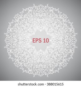 Openwork mandala pattern. White circular pattern on a simple gray background.