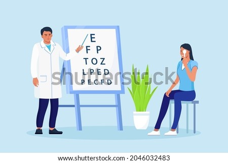 Ophthalmology diagnostics, vision correction, optometry. Ophthalmologist checking eyesight of patient. Oculist standing near eye test board and showing letter to woman. Eye clinic appointment 