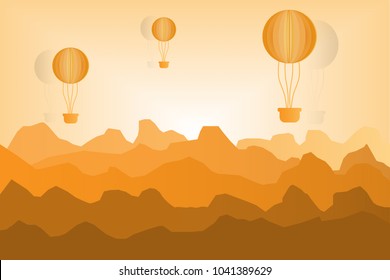 Orange balloon floating on the mountain at sunset.
