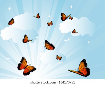 Orange butterflies against cloudy blue sky