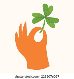 An orange hand holding a four leaf clover.