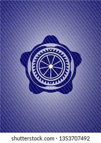 orange icon inside emblem with denim texture