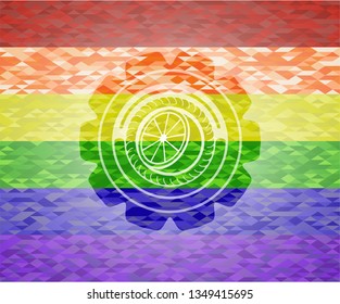 orange icon inside emblem on mosaic background with the colors of the LGBT flag
