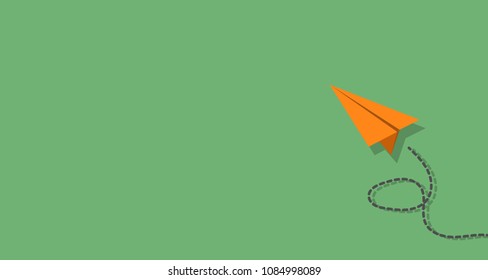 Orange paper plane on green background with copy space for your text