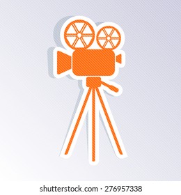 Orange retro movie camera icon on striped background