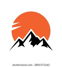 Orange sun setting behind silhouette of mountain range landscape