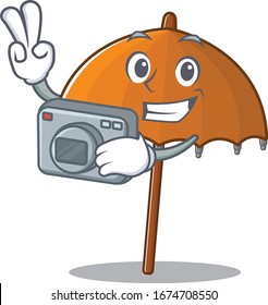 Orange umbrella mascot design as a professional photographer with a camera
