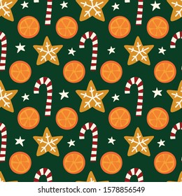 Oranges, cookies, candy canes seamless vector Christmas pattern. Winter spices repeating background. Hand drawn isolated objects on green background. Use for holiday cards, fabric, decor, packaging