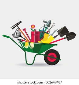 Organic farming. Wheelbarrow with tools to work in the garden. Adaptations for planting, digging up the ground, irrigation, fertilizer, spraying, weed control. White background.