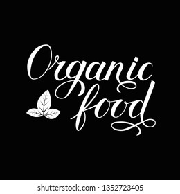 Organic food hand written phrase with leaves isolated on black background. Calligraphy lettering sign. Healthy food concept. Vector logo design  for fresh market, restaurant, farm, store, etc.