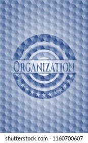 Organization blue emblem or badge with abstract geometric pattern background.