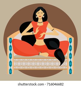 Oriental beauty sitting on the couch in lotus position on colored background with a round substrate