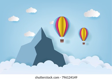 Origami made colorful hot air balloon flying over the mountain with cloud.paper art style.