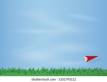 Origami made of grass and red plane floating in the air on beautiful sky background. paper art design and craft style. copy space.
