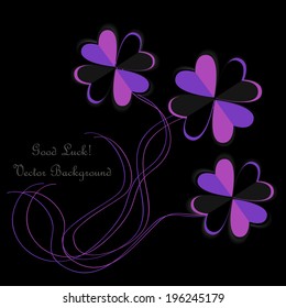 origami paper four leaf clovers on black background