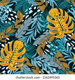 Original seamless tropical pattern with bright yellow and white plants and leaves on a blue background. Seamless pattern with colorful leaves and plants. Exotic jungle wallpaper.