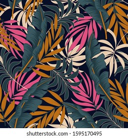 Original seamless tropical pattern with bright yellow and pink plants and leaves on a dark background. Vintage pattern. Seamless exotic pattern with tropical plants.