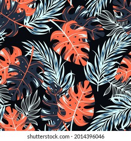 Original seamless tropical pattern with bright colorful plants and leaves on a dark background. Trendy summer Hawaii print. Modern abstract design for fabric, paper, interior decor.