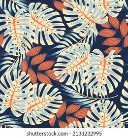 Original seamless tropical pattern with bright plants and leaves on a blue background. Seamless pattern with colorful leaves and plants. Colorful stylish floral. Printing and textiles.