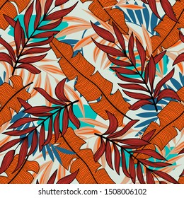 Original seamless tropical pattern with plants and leaves in bright colors on a pastel background. Colorful stylish floral. Trendy summer Hawaii print. Seamless exotic pattern with tropical plants.