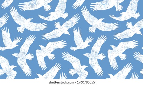 Ornamental decorative seamless pattern with soaring stylized birds. Flying white crows on blue sky background. Vector illustration. 