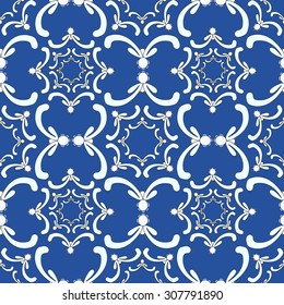 Ornamental seamless pattern. Vintage template. White curve elements on the blue background. Filigree texture.