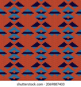 Ornate knitting seamless vector pattern in orange and blue hues as a fabric texture