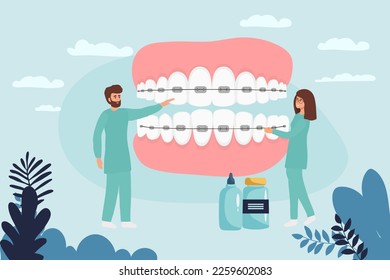 Orthodontist installs dental braces for straightening. Tiny Dentist doctor research X-ray picture of tooth. Dentistry, braces installation, teeth alignment. Prosthetics, Orthodontic treatment.