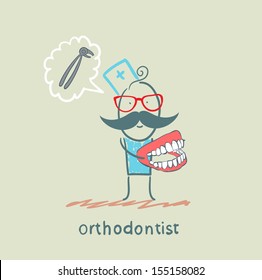 orthodontist with the jaw in the hands of thinking about the tool for pulling teeth