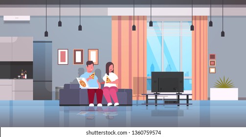 Over Size Couple Eating Pizza Man Woman Watching Tv Sitting On Couch Unhealthy Fast Food Obesity Concept Modern Living Room Interior Full Length Flat Horizontal